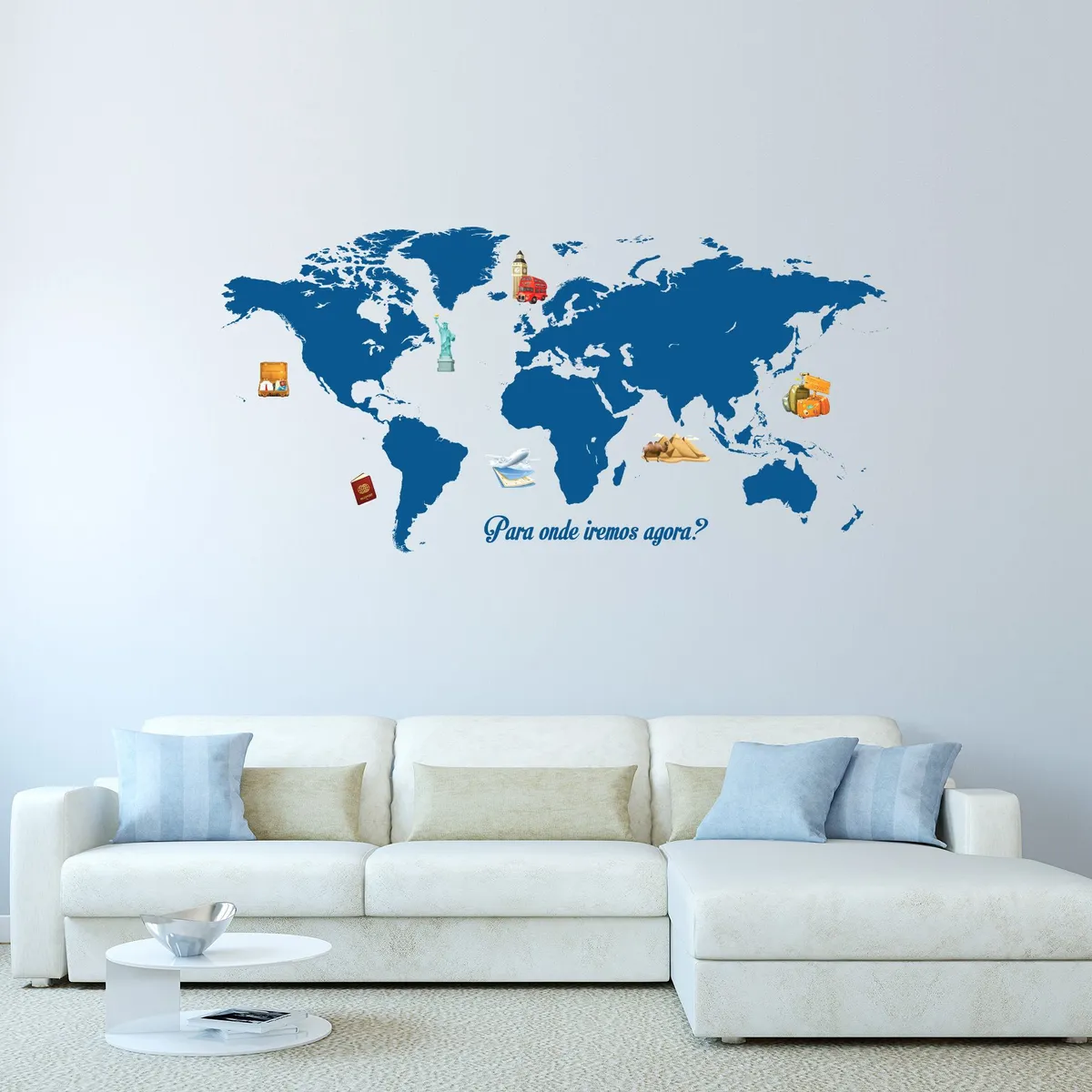 Adesivo de parede mapa mundi aplicado em parede branca acima de sofá branco com almofadas azuis e bege, ambiente moderno e minimalista.