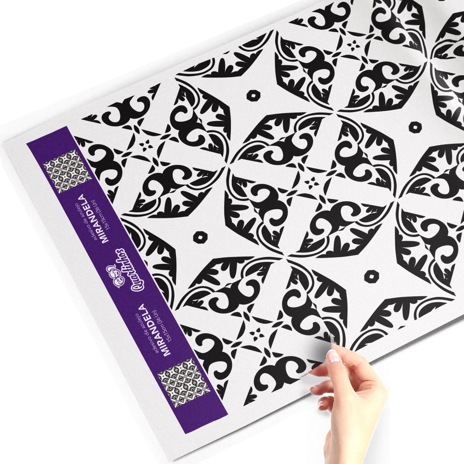 Folha de adesivo para azulejo com padrão preto e branco geométrico e floral, segurada por uma mão.