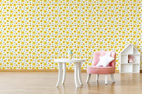 Ambiente decorado com papel de parede infantil estampado com girassóis amarelos pequenos e abelhas em fundo branco